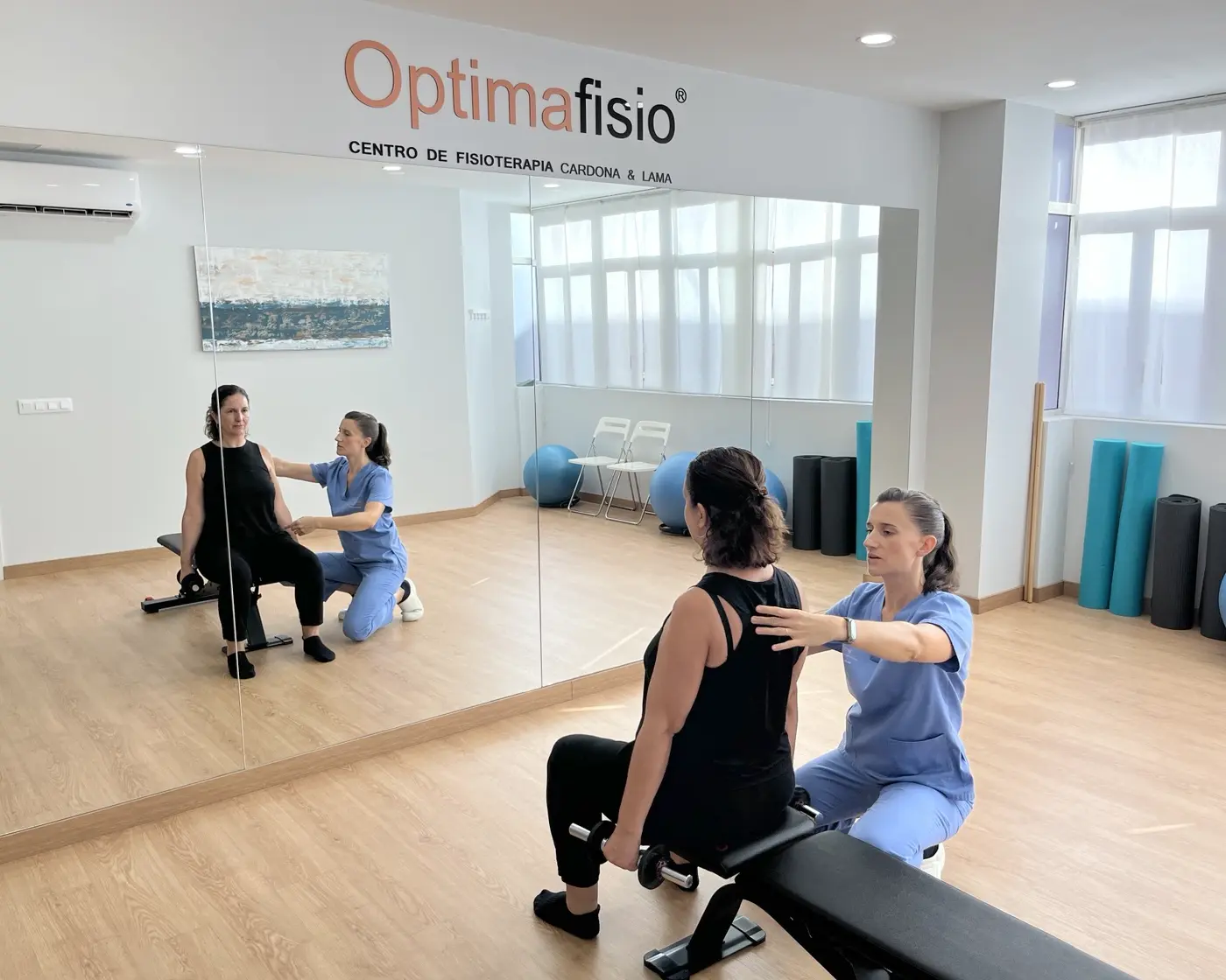 Mariangela Lama guiando a una paciente durante un ejercicio frente al espejo en Optimafisio