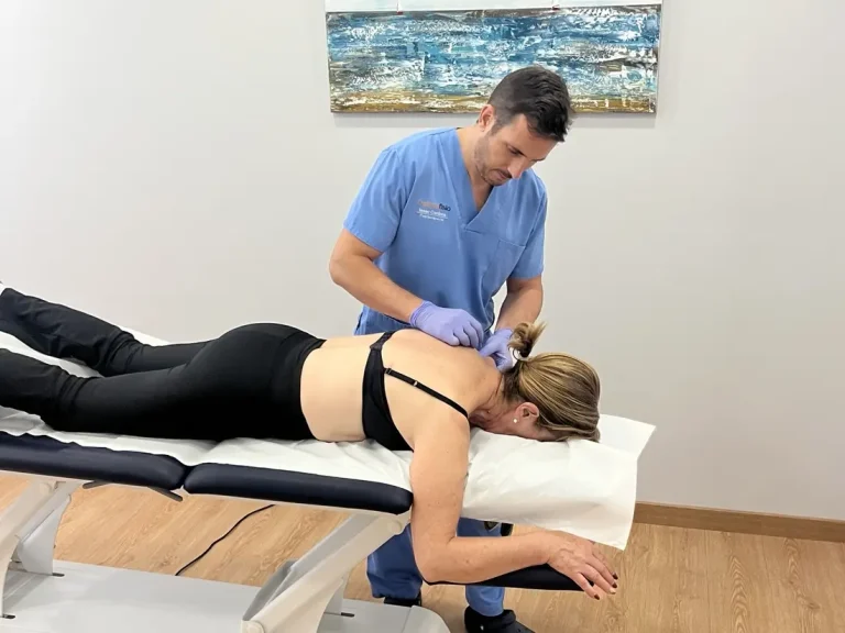 Isaac Cardona tratando la zona cervical de una paciente en Optimafisio