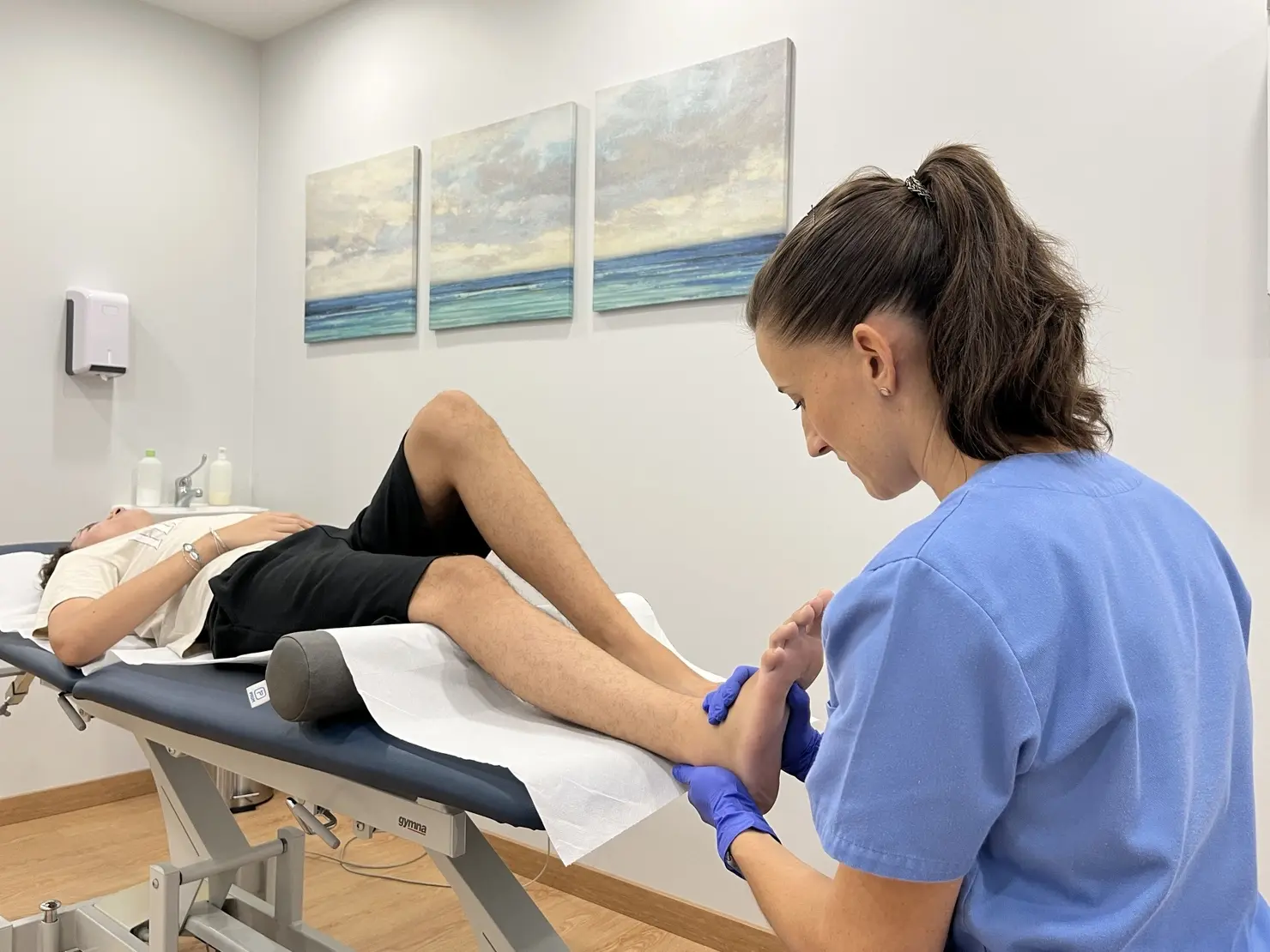 Mariangela Lama realizando terapia manual en el pie y tobillo de un paciente en Optimafisio